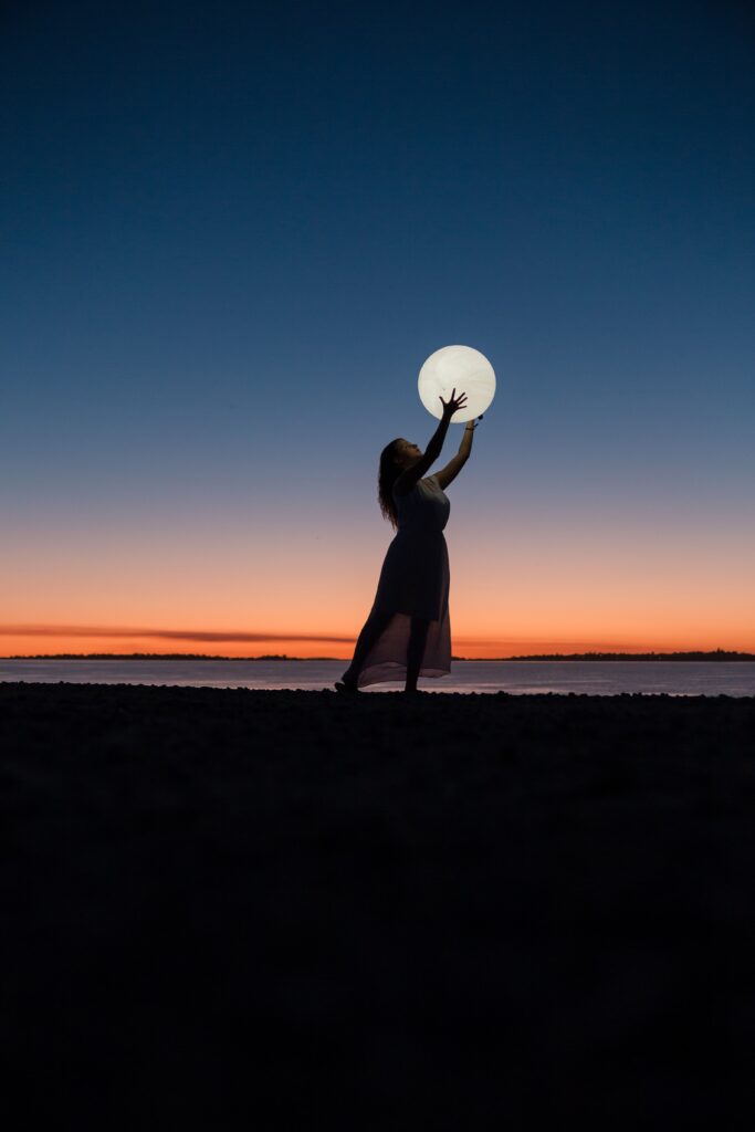 Illusion of a woman holding the moon.